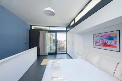 a bedroom with a white bed and a large window at Bright Modern Design New Duplex Loft Patio! #145 in Istanbul