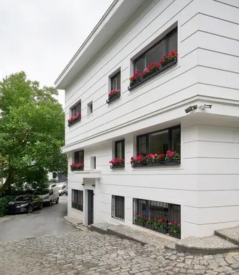 a white building with red flowers in windows at Cute Charming 1bed1bath Bebek Hidden Gem! #77 in Istanbul