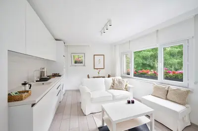 a white kitchen and living room with a couch and a table at Bright Modern new 1bed1bath Hidden Gem Bebek! #78 in Istanbul