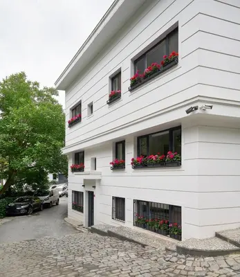 a white building with red flowers in window boxes at Bright Modern new 1bed1bath Hidden Gem Bebek! #78 in Istanbul