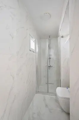 a white bathroom with a shower and a toilet at Bright Modern new 1bed1bath Hidden Gem Bebek! #78 in Istanbul