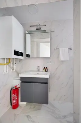 a white bathroom with a sink and a red fire extinguisher at Modern Bright Cozy 1bed1bath Hidden Gem! #79 in Istanbul
