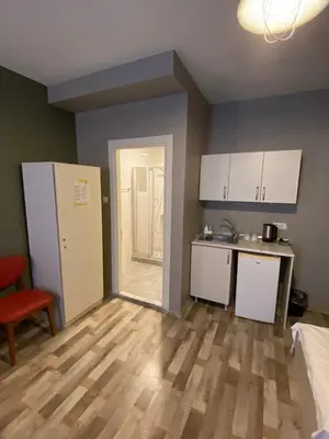 a kitchen with white cabinets and a wooden floor at Puffin Boutique - Istanbul in Istanbul