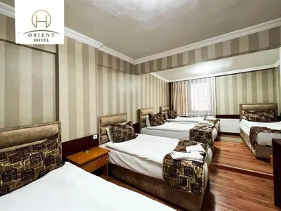 a hotel room with four beds and a sign that reads urgent hotel at Orient Hotel in Istanbul