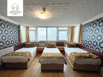 a room with three beds and a window at Orient Hotel in Istanbul