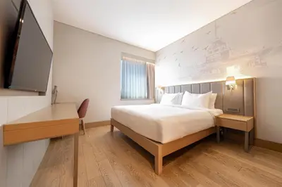 a bedroom with a bed and a desk and a tv at Radisson Hotel Istanbul Harbiye in Istanbul
