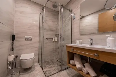 a bathroom with a shower and a toilet and a sink at Radisson Hotel Istanbul Harbiye in Istanbul