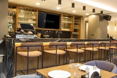 a bar in a restaurant with chairs and tables at Radisson Hotel Istanbul Harbiye in Istanbul
