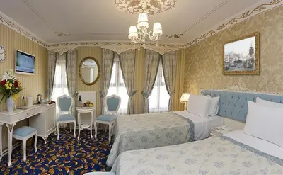 a hotel room with two beds and a vanity and a desk at Villa Paradiso Hotel & Spa in Istanbul