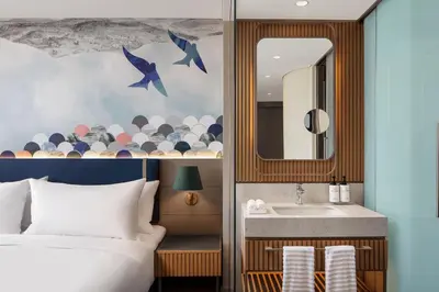 a bedroom with a bed and a sink and a mirror at Lokalist, Istanbul, a Tribute Portfolio Hotel in Istanbul