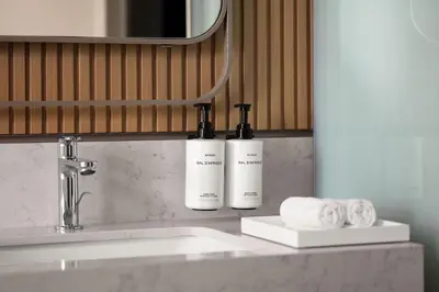 two bottles ofodorizers are sitting on a bathroom sink at Lokalist, Istanbul, a Tribute Portfolio Hotel in Istanbul
