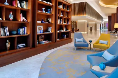 a library with two chairs and bookshelves at Istanbul Marriott Hotel Sisli in Istanbul