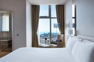 a hotel room with a bed and a chair and a window at Istanbul Marriott Hotel Sisli in Istanbul