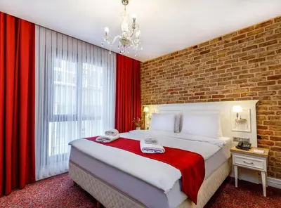 a bedroom with a large bed with red curtains at La Porte de Taksim in Istanbul