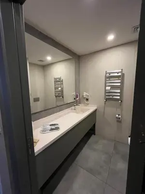 a bathroom with a sink and a large mirror at Agora Royal Residence in Esenyurt