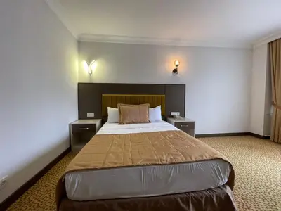a bedroom with a large bed with two night stands at SEFA HOTEL 1 ÇORLU in Corlu