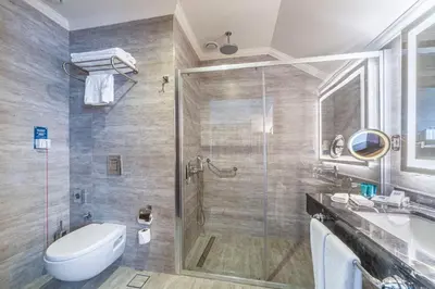 a bathroom with a shower and a toilet and a sink at TRYP By Wyndham Istanbul Sisli Hotel in Istanbul