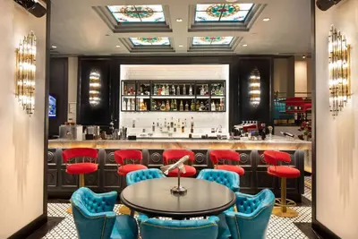 a bar with blue chairs and a table and a counter at TRYP By Wyndham Istanbul Sisli Hotel in Istanbul