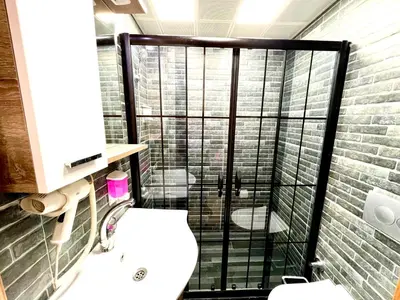 a bathroom with a toilet and a glass shower at LEVENT PALACE REZİDANS in Istanbul