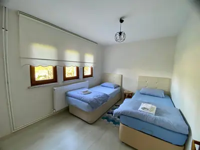 a bedroom with two beds and two windows at Maşukiye Home Suit Apart in Kartepe