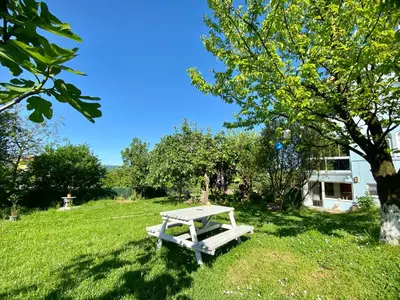 a picnic table sitting in the grass next to a tree at Maşukiye Home Suit Apart in Kartepe
