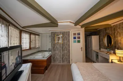 a bedroom with a bed and a tub and a television at Fuat Bey Palace Hotel & Spa in Istanbul