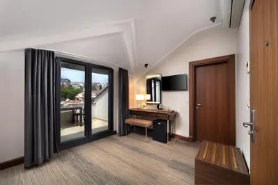 a hotel room with a desk and a balcony at Recital Park Hotel in Istanbul