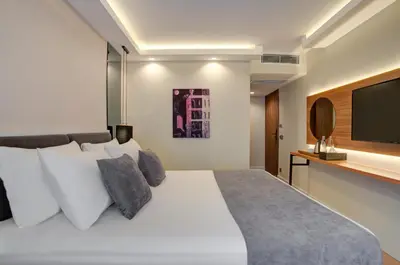 a bedroom with a white bed and a flat screen tv at Depiero Hotel Karaköy in Istanbul