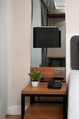 a bedroom with a table with a phone and a lamp at Depiero Hotel Karaköy in Istanbul