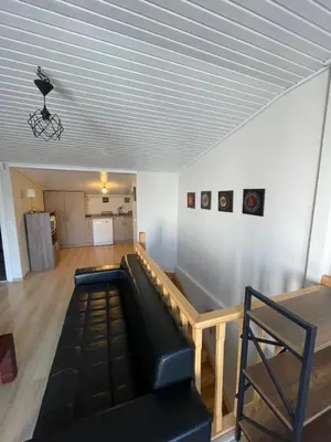 a living room with a black couch and a table at Duplex with terrace in center,5mn walk to Istiklal in Istanbul