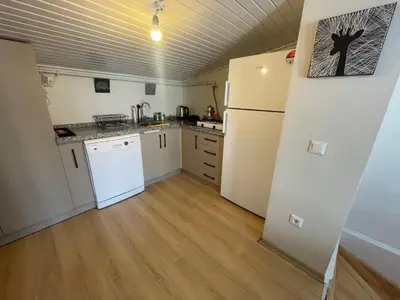 a kitchen with white appliances and a wooden floor at Duplex with terrace in center,5mn walk to Istiklal in Istanbul