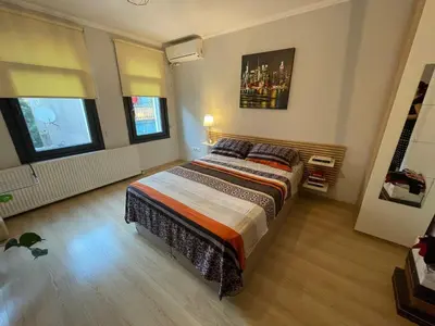 a bedroom with a large bed and two windows at Duplex with terrace in center,5mn walk to Istiklal in Istanbul