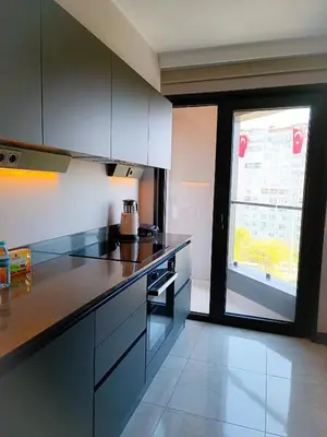 a kitchen with black and white cabinets and a window at Luxury Fully Equipped 3BR 2BA Apartment by Siena Suites in Istanbul