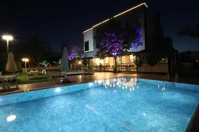 a swimming pool in front of a building at night at İncipark Hotel in Sakarya