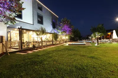 a building with a lawn in front of it at night at İncipark Hotel in Sakarya