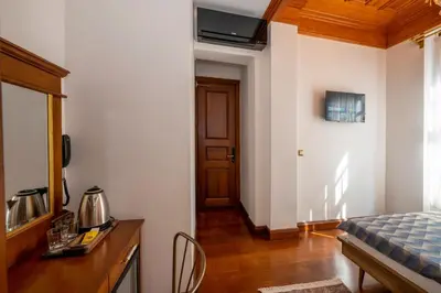 a bedroom with a bed and a table and a door at Valeria Antique 1892 in Istanbul