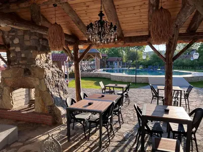 a patio with tables and chairs under a wooden roof at Dachas Cove Hotel in Agva