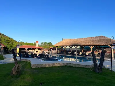 a resort with a swimming pool and a thatch roof at Dachas Cove Hotel in Agva