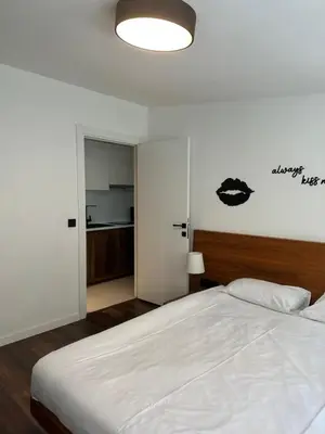 a bedroom with a large white bed and a kitchen at City Aparts Nisantasi in Istanbul