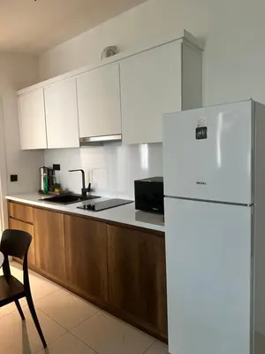 a kitchen with white cabinets and a white refrigerator at City Aparts Nisantasi in Istanbul