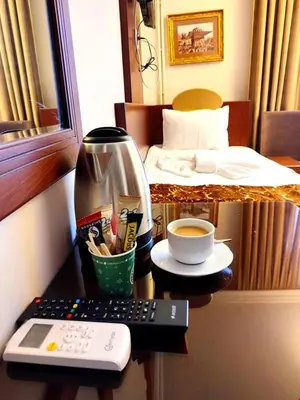 a desk with a remote control and a cup of coffee at HOTEL EURO DIAMOND in Istanbul
