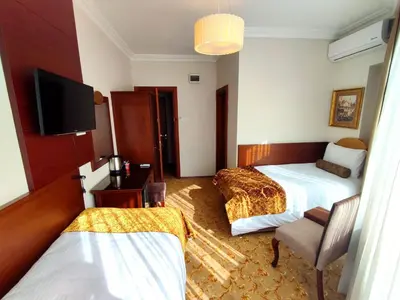 a hotel room with two beds and a flat screen tv at HOTEL EURO DIAMOND in Istanbul