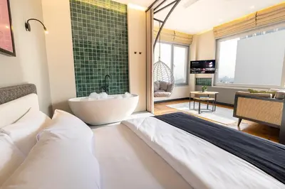 a bedroom with a large bed and a tub at Upside Apartments in Istanbul