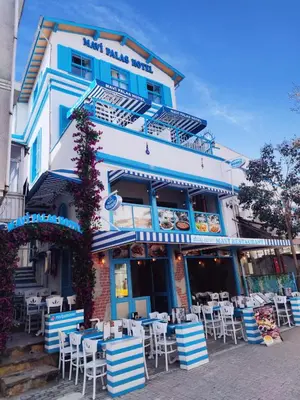 a building with tables and chairs in front of it at MAVİ PALAS HOTEL in Buyukada