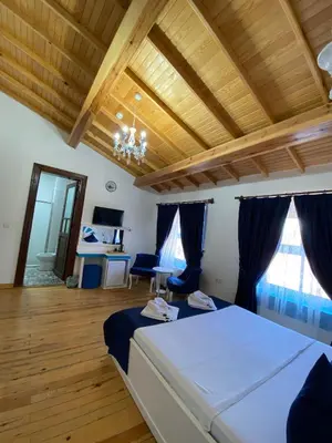 a bedroom with a bed and a wooden ceiling at MAVİ PALAS HOTEL in Buyukada