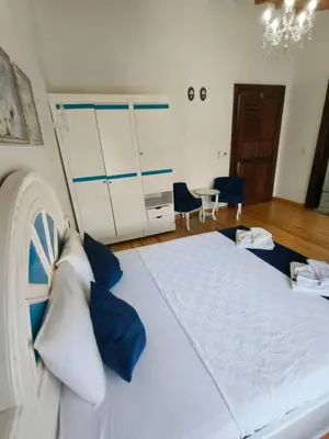 a bedroom with a large bed with blue and white pillows at MAVİ PALAS HOTEL in Buyukada