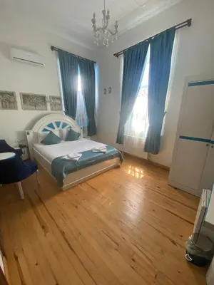 a bedroom with a bed and a wooden floor at MAVİ PALAS HOTEL in Buyukada