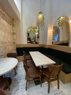 two tables and chairs in a restaurant with two mirrors at Pera Rasso Hotel in Istanbul