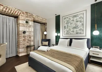 a bedroom with a large bed and a brick wall at Pera Rasso Hotel in Istanbul