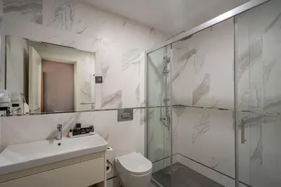 a bathroom with a shower and a toilet and a sink at ERTA SOYAK THERMAL OTEL in Çekirge